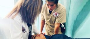 Massage therapy student and instructor practicing on another student.