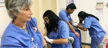 Students learning phlebotomy techniques.