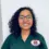 Maria Z., a Healthcare Career College graduate, wearing scrubs with a school patch and smiling