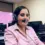 Viviana R., an employed graduate of the Medical Biller and Coder Program, wearing a headset at her office desk